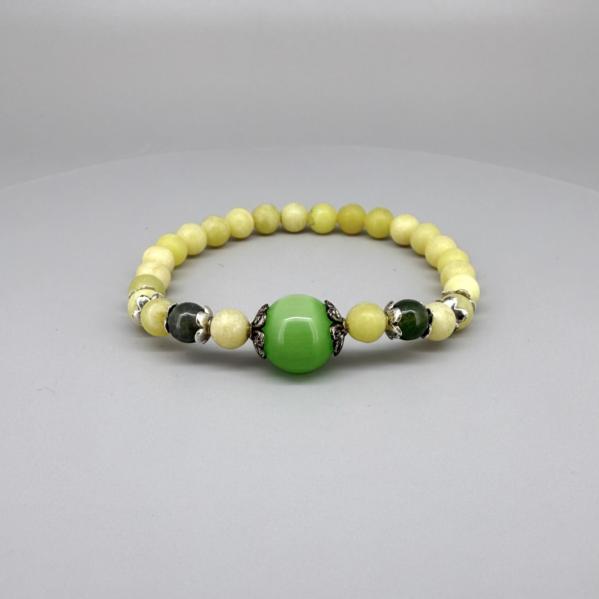 Yellow jade beaded bracelet, 18cm, with larger green jade focal bead on elastic stretch band.
