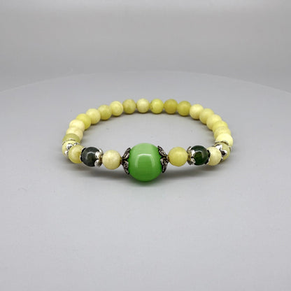 Yellow jade beaded bracelet, 18cm, with larger green jade focal bead on elastic stretch band.