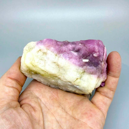 Natural ruby in creamy-white matrix, pink to purplish-pink rough corundum partially encased in host rock.