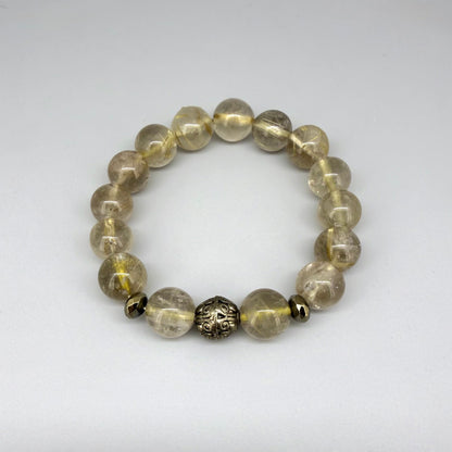 Rutilated quartz beaded bracelet, natural golden rutile gemstone beads with one carved metal accent bead on elastic stretch band.