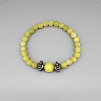 Yellow jasper beaded bracelet, 18cm, vibrant gemstone beads with larger focal bead framed by carved metal accents on elastic stretch band.