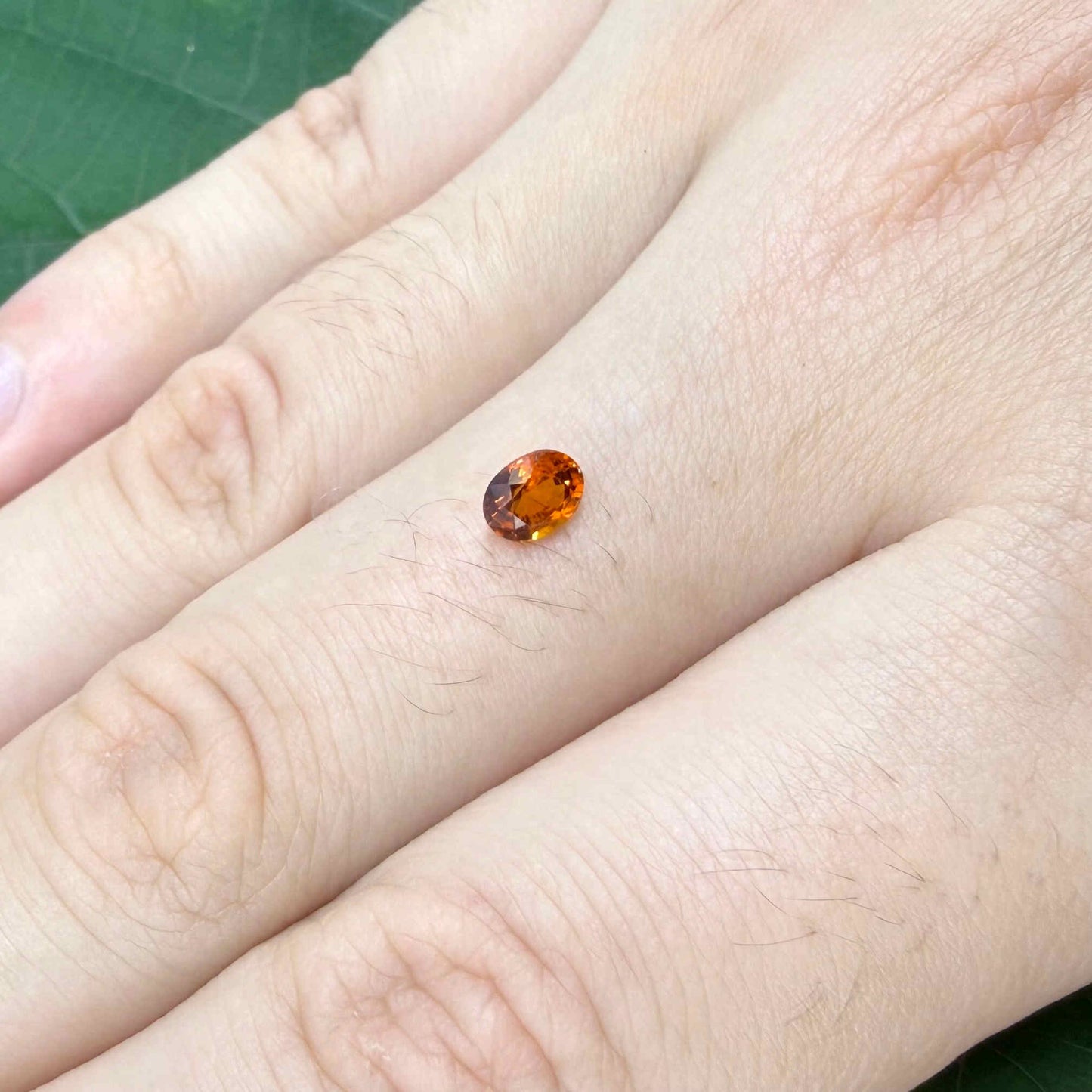 0.56 ct natural spessartine garnet from Namibia, fiery orange, faceted.