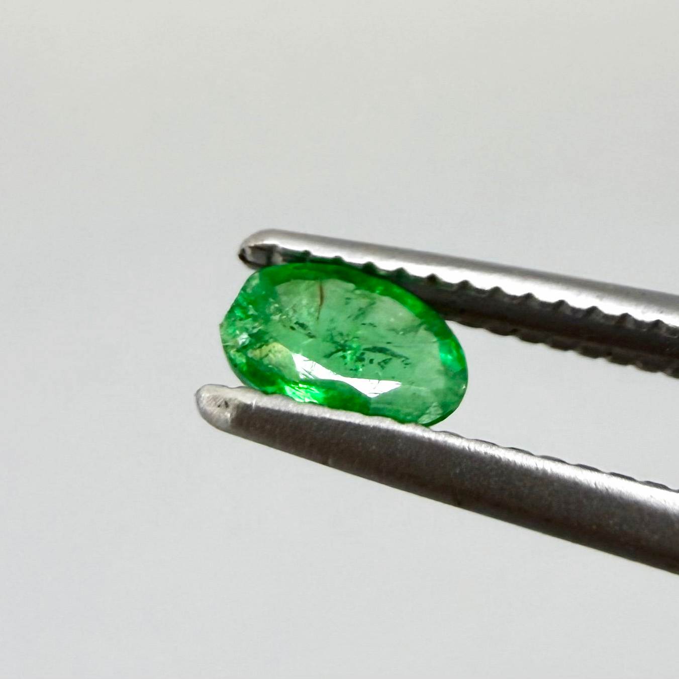 0.16 ct natural untreated Zambian emerald, oval faceted with bright bluish-green color.