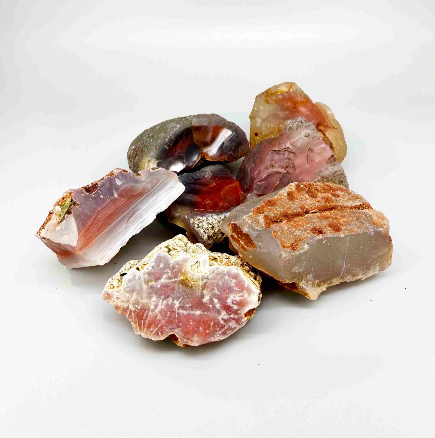 Mixed chalcedony rough stones with pink, orange-red and grey banded patterns, natural quartz lot.