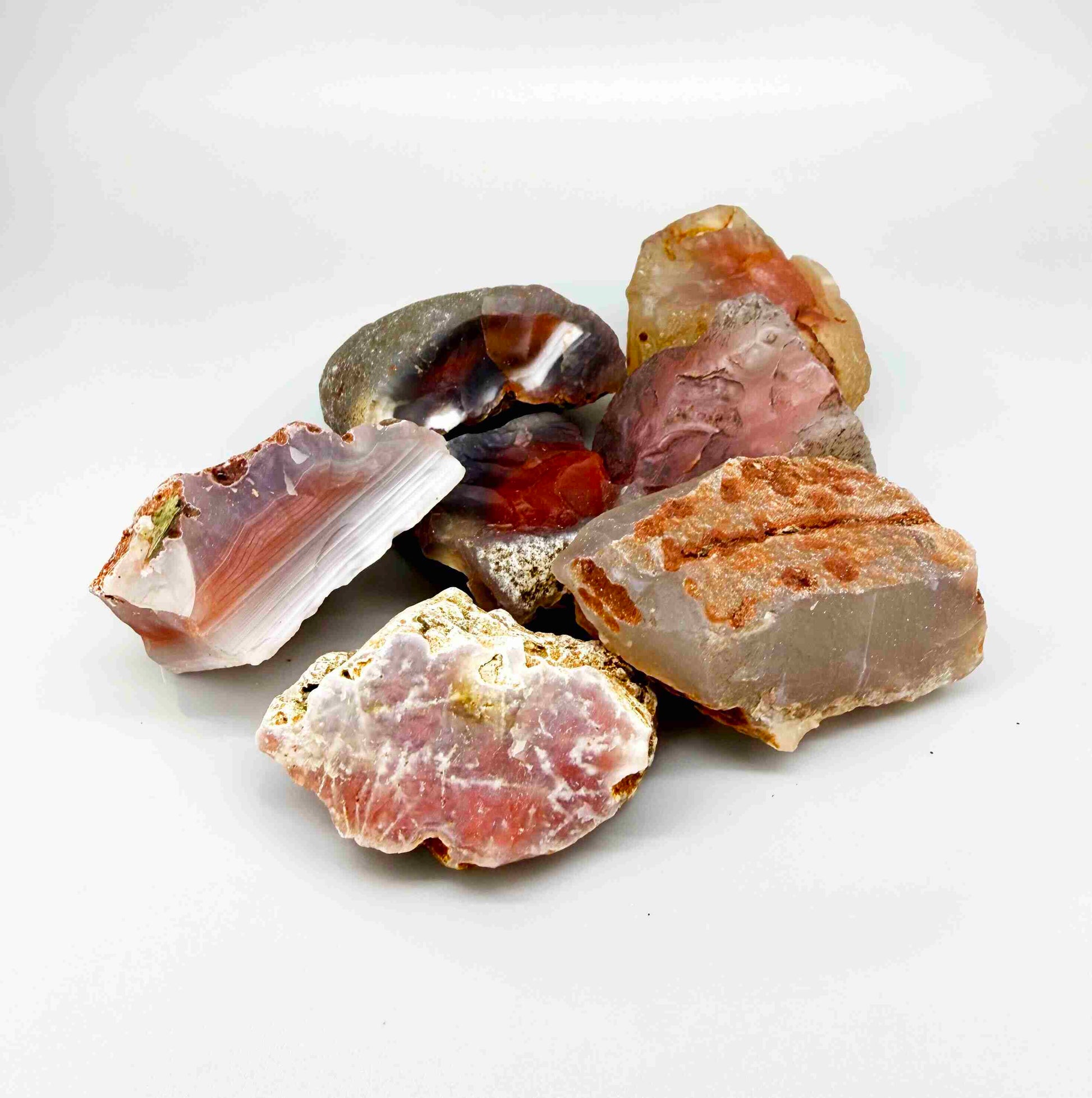 Mixed chalcedony rough stones with pink, orange-red and grey banded patterns, natural quartz lot.