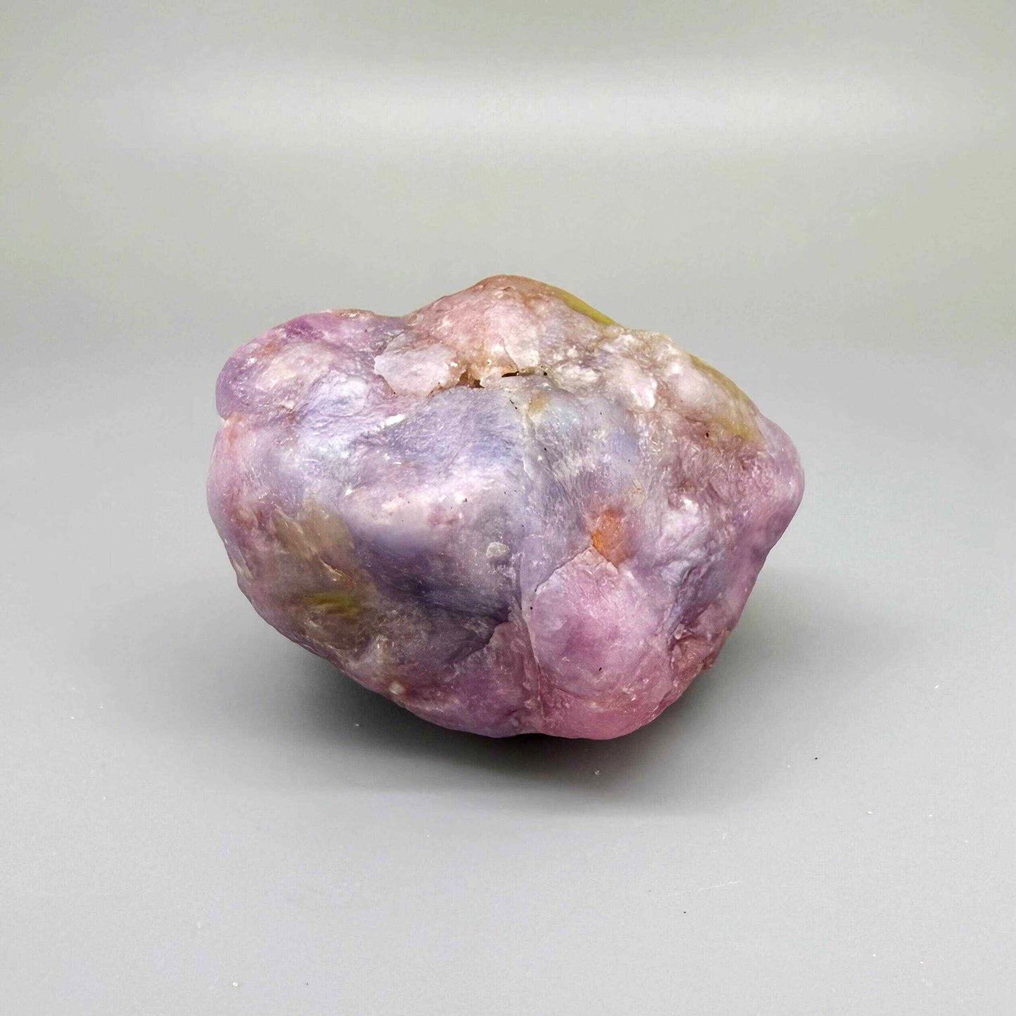 Natural ruby rough stone in lilac to purplish-pink tones, uncut corundum specimen.