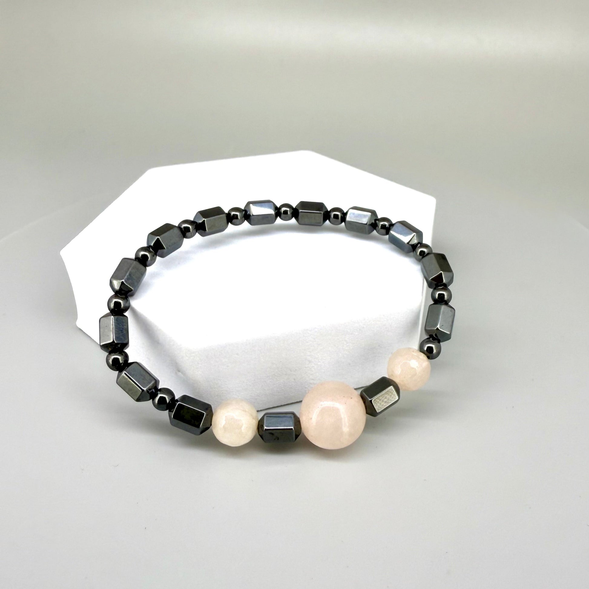 Hematite and rose quartz beaded bracelet, 18cm, geometric metallic grey beads with three pink rose quartz accents on elastic stretch band.