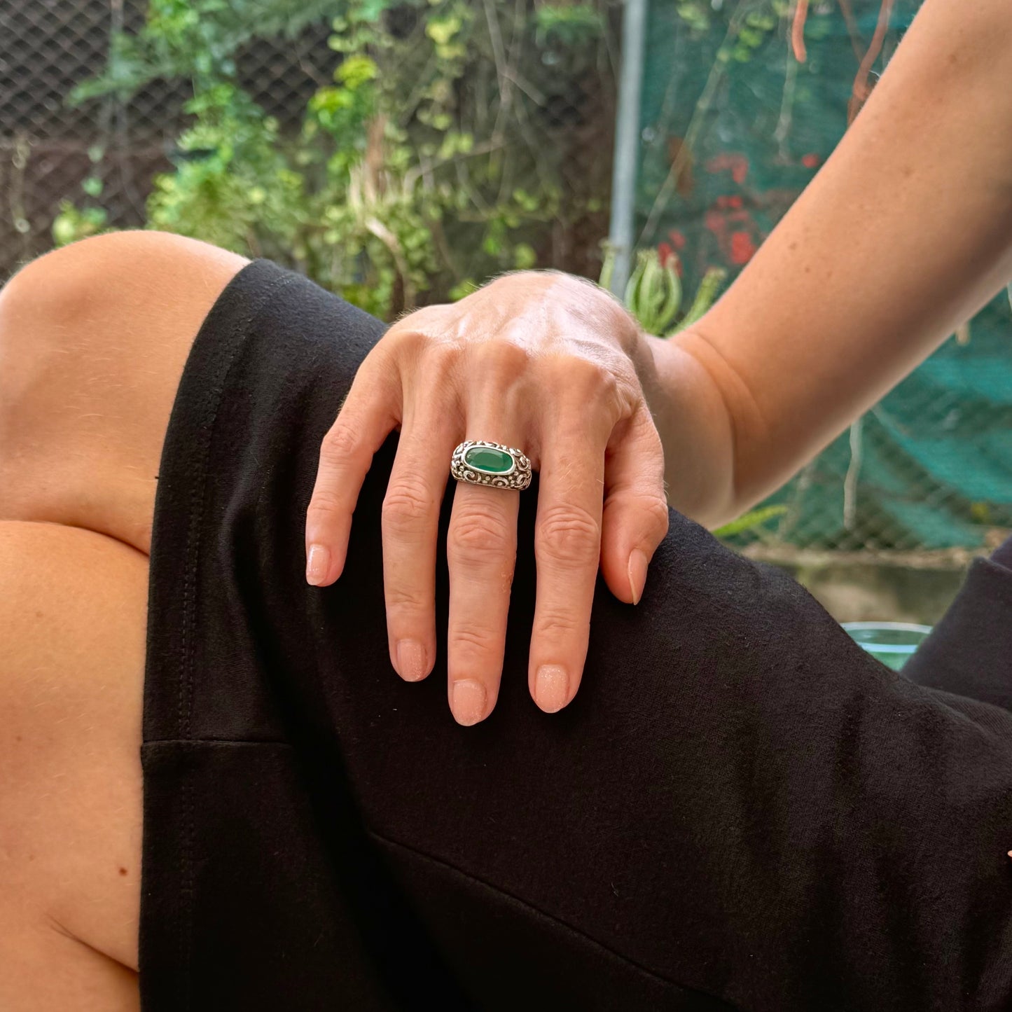 White gold plated sterling silver ring featuring an oval green chalcedony gemstone in a textured silver band.