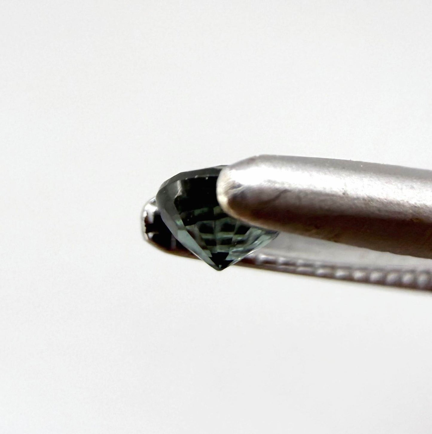 0.15 ct natural greenish-blue sapphire from Bangkaja, round cut.