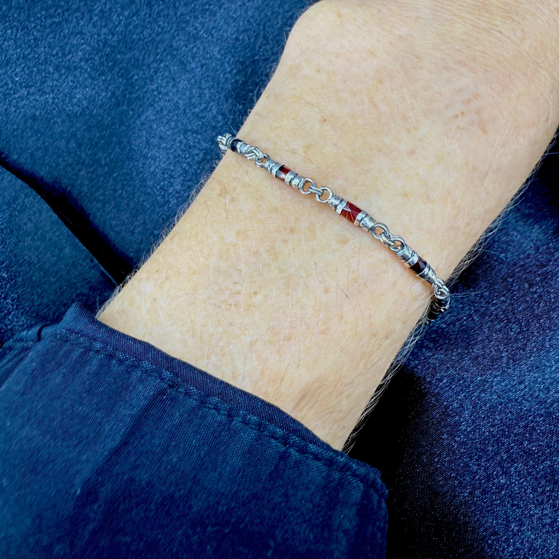 Garnet Pyrope bracelet in sterling silver with white gold plating, elegant design on neutral background