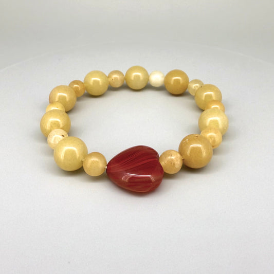 Jade and carnelian beaded bracelet, 20cm, yellow-cream jade beads with large heart-shaped orange-red carnelian focal stone on elastic stretch band.