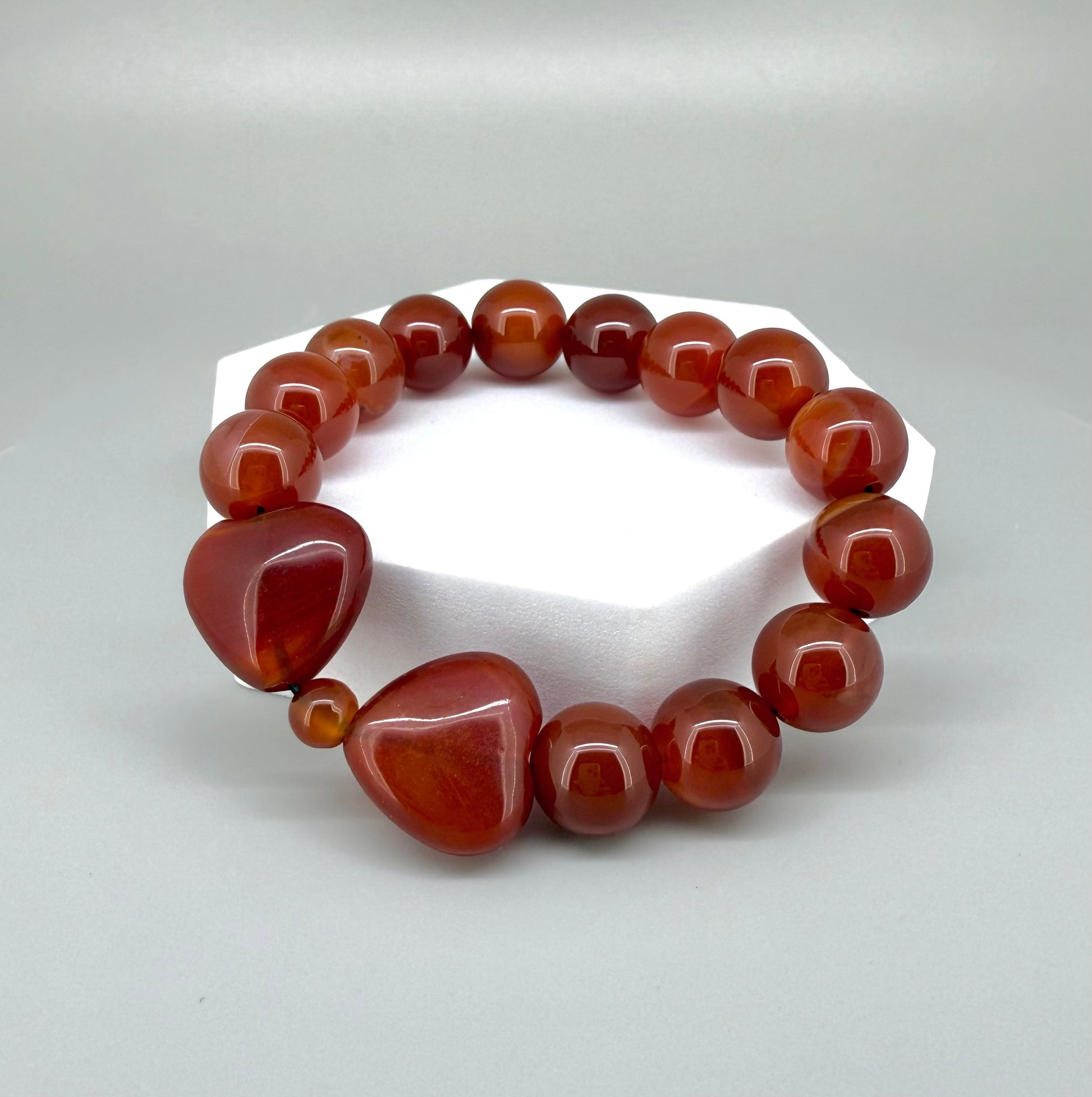 Carnelian beaded bracelet, 19cm, natural orange-red gemstone beads with two larger heart-shaped carnelian stones on elastic stretch band.