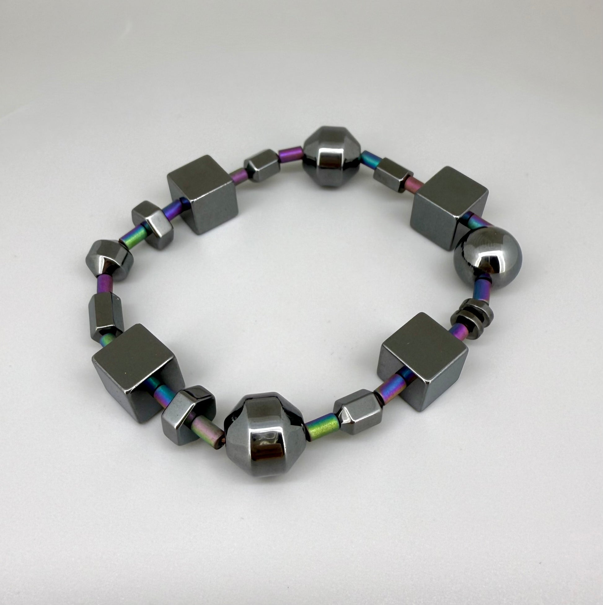 Hematite bracelet, 20cm, geometric cube and sphere beads with rainbow-toned connectors on elastic stretch band.
