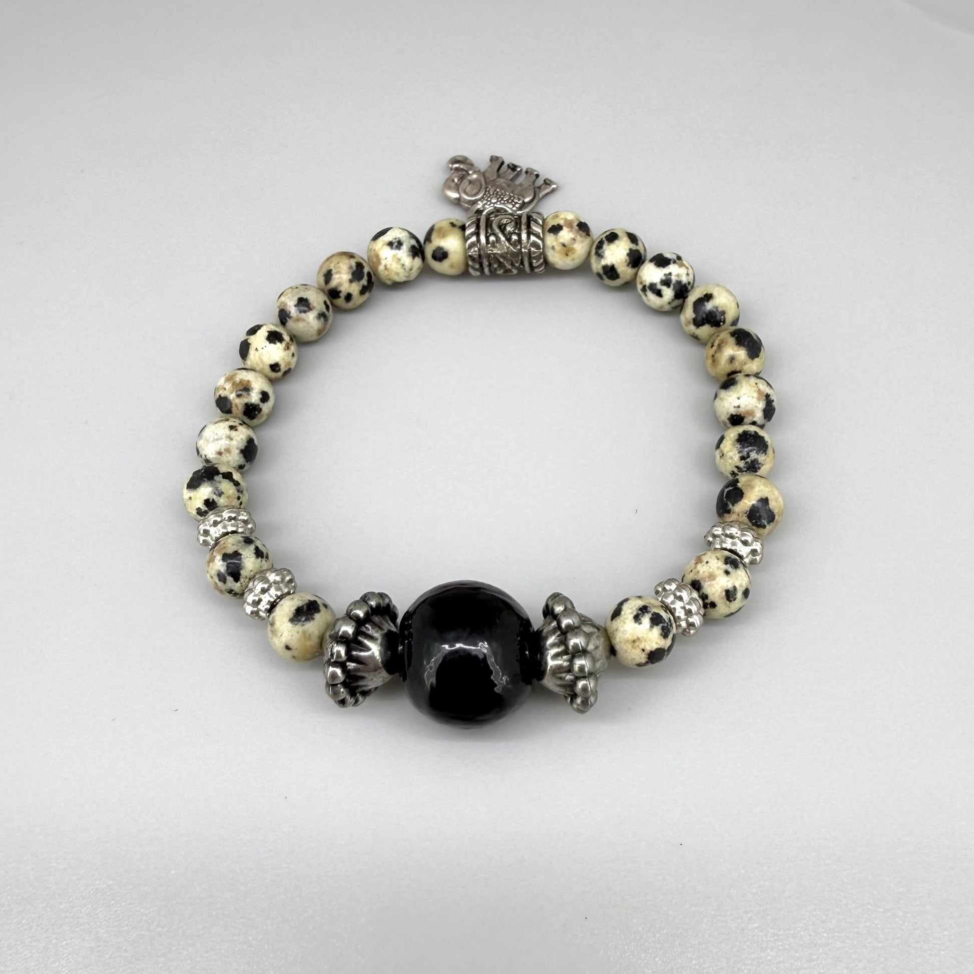 Dalmatian jasper beaded bracelet, 17cm, cream with black speckled gemstone beads and one large black accent bead on elastic stretch band.