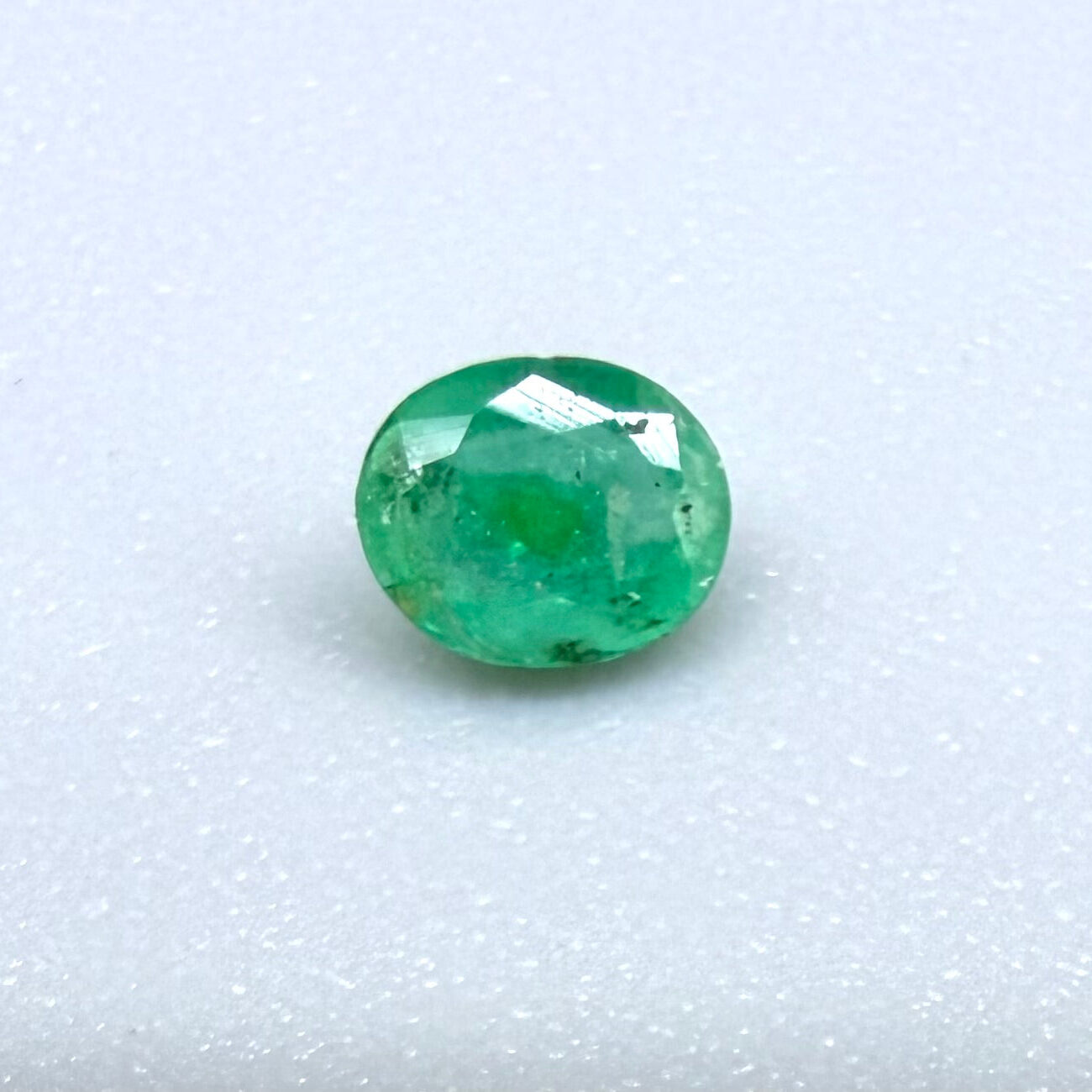 0.2 ct natural untreated Zambian emerald, oval faceted with bright bluish-green color.