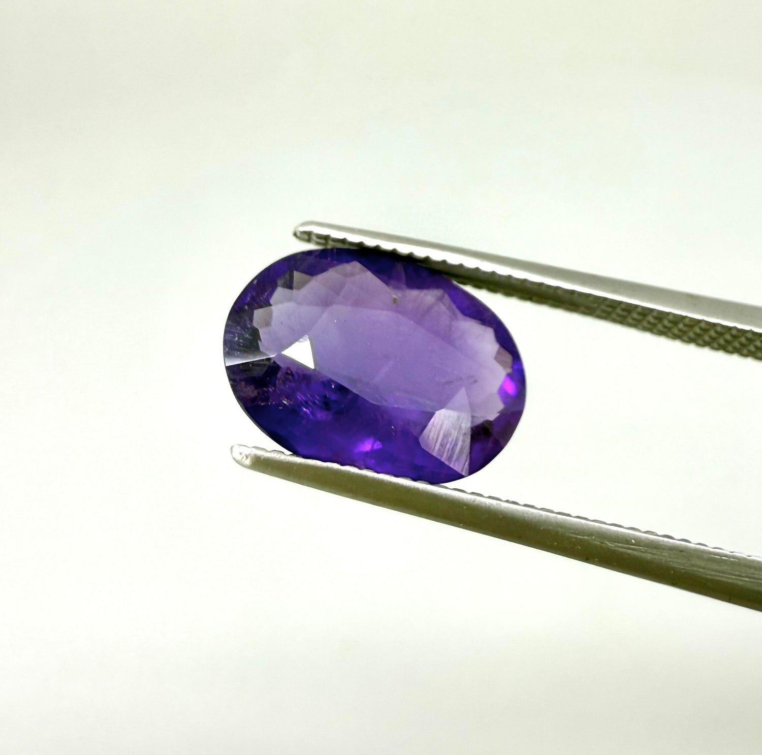 Round purple gemstone on a white background
