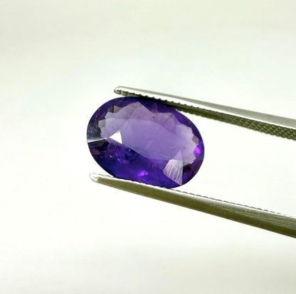 Round purple gemstone on a white background
