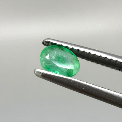 0.2 ct natural untreated Zambian emerald, oval faceted with bright bluish-green color.