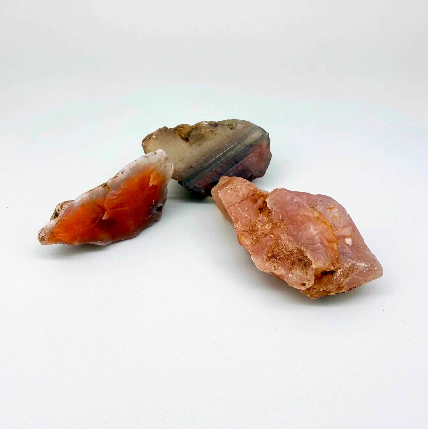 Rough and uncut chalcedony/carnelian lot in natural red-orange tones, untreated raw gemstones.