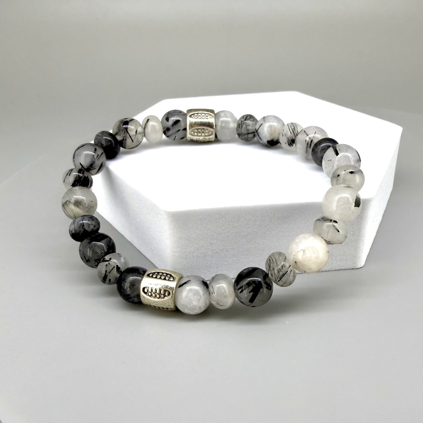 Rutilated quartz beaded bracelet, 18cm, black-white-grey gemstone beads with two decorated metal spacers on elastic band.