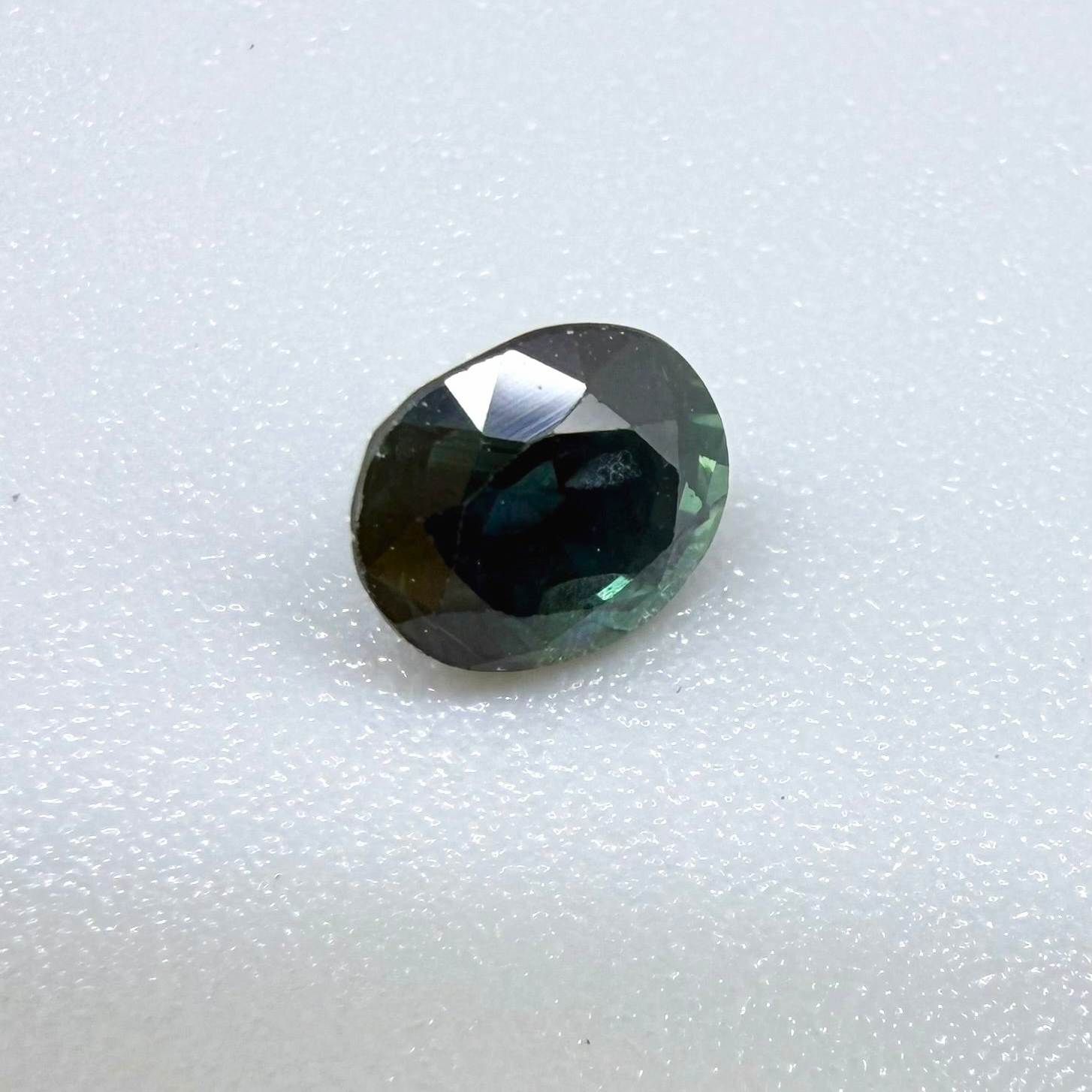 0.67 ct natural blue-green sapphire from Bangkaja, faceted cut.
