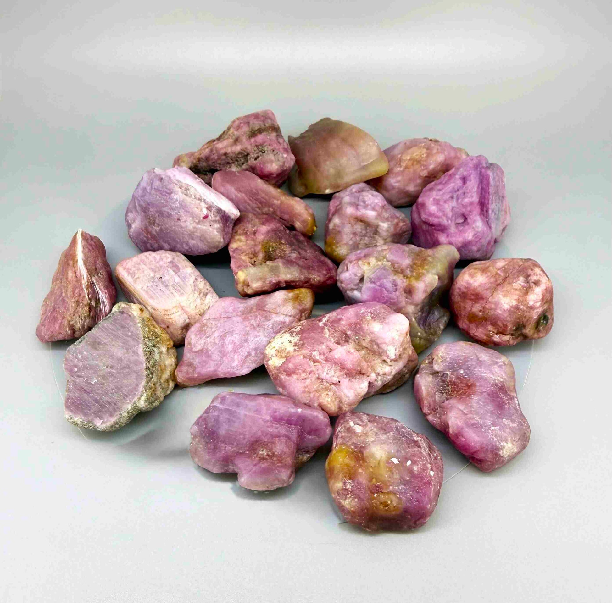 Natural ruby rough lot weighing approximately 1,380 g, featuring pink to lilac-pink corundum stones in raw form.