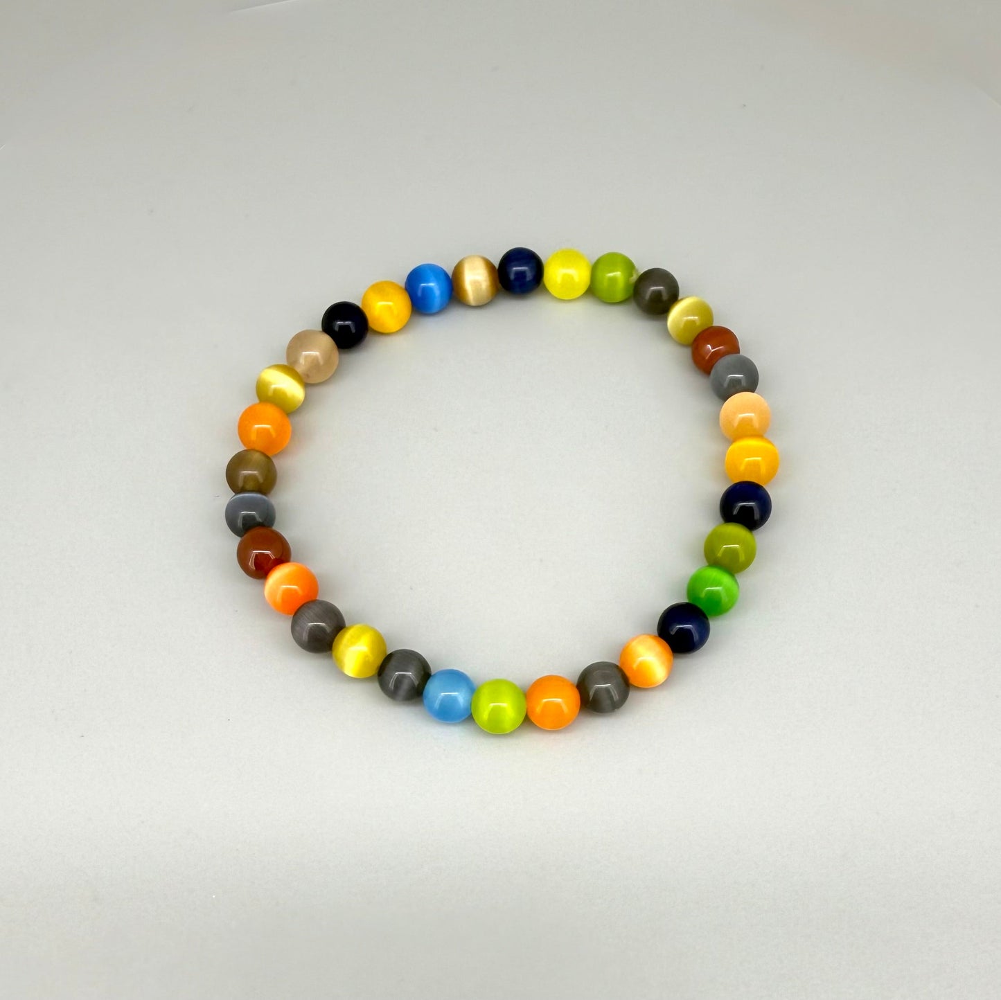 Multicolor cat’s eye beaded bracelet, 18cm, vivid gemstone beads in bright, brown, and black tones with shimmering effect on elastic stretch band.