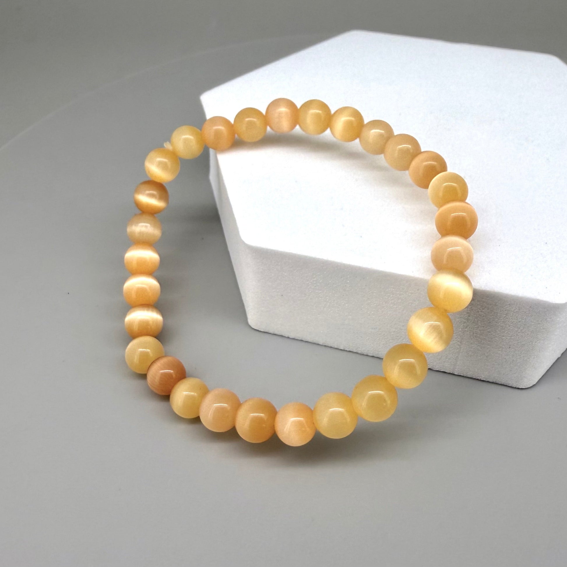 Cat’s Eye beaded bracelet, peach-orange gemstone beads with shimmering light effect on elastic stretch band.
