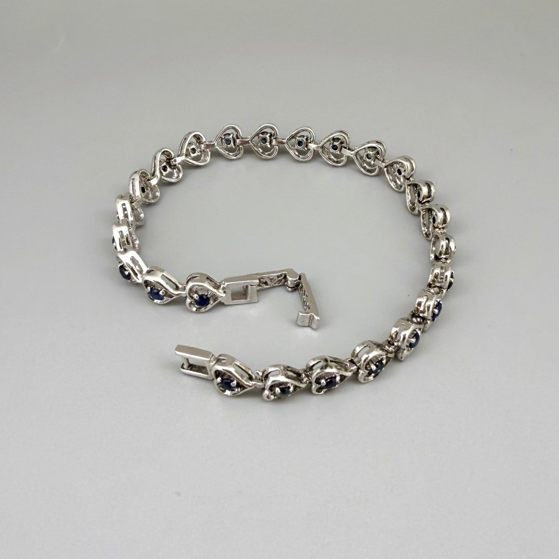 Sapphire bracelet in sterling silver with white gold plating, elegant design on neutral background