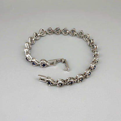 Sapphire bracelet in sterling silver with white gold plating, elegant design on neutral background