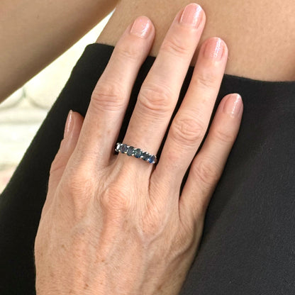 Blue sapphire ring in white gold plated sterling silver on neutral background