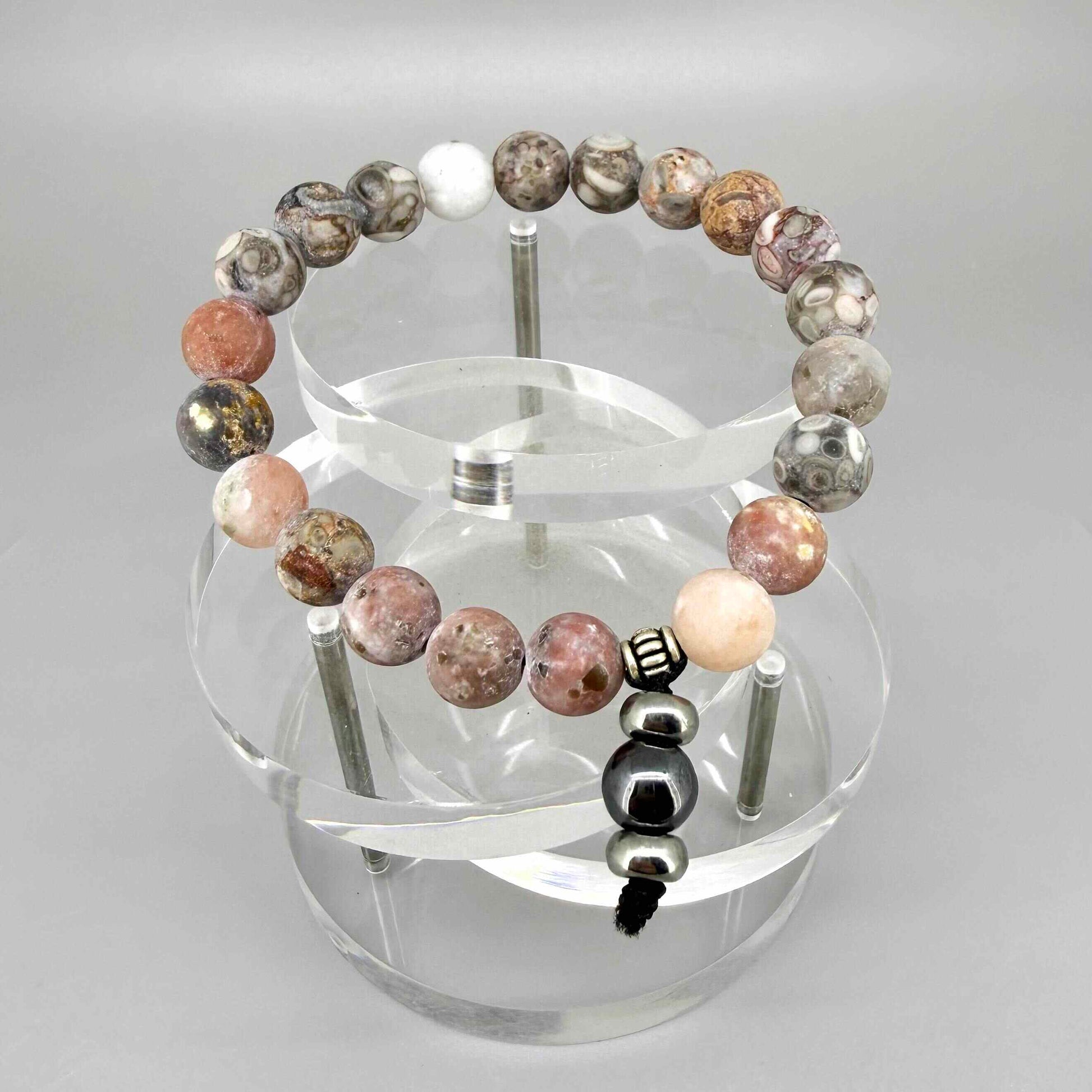 Maifanite mala bracelet with natural earthy-toned beads in beige, grey and soft terracotta shades, featuring a subtle charm detail.