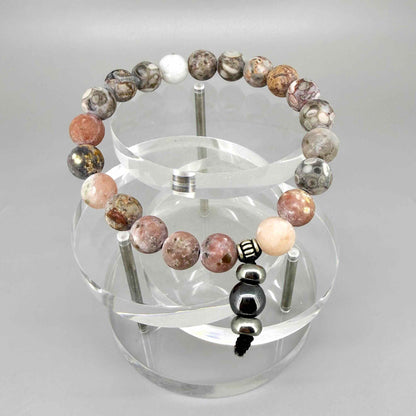 Maifanite mala bracelet with natural earthy-toned beads in beige, grey and soft terracotta shades, featuring a subtle charm detail.