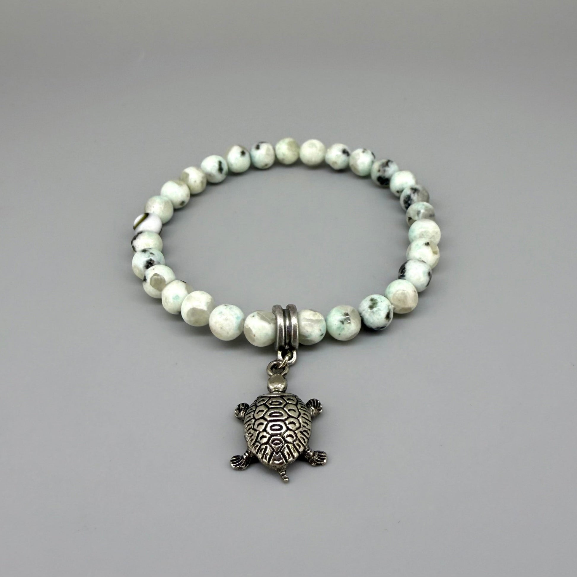 Dalmatian jasper beaded bracelet, 18cm, earthy gemstone beads with metal turtle charm on elastic stretch band.