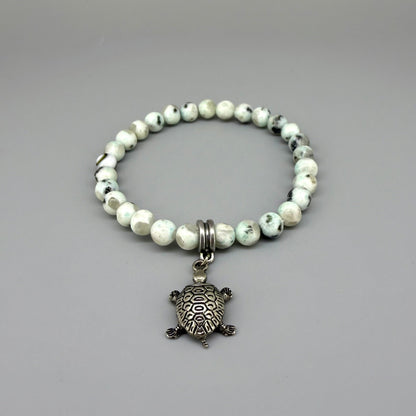 Dalmatian jasper beaded bracelet, 18cm, earthy gemstone beads with metal turtle charm on elastic stretch band.