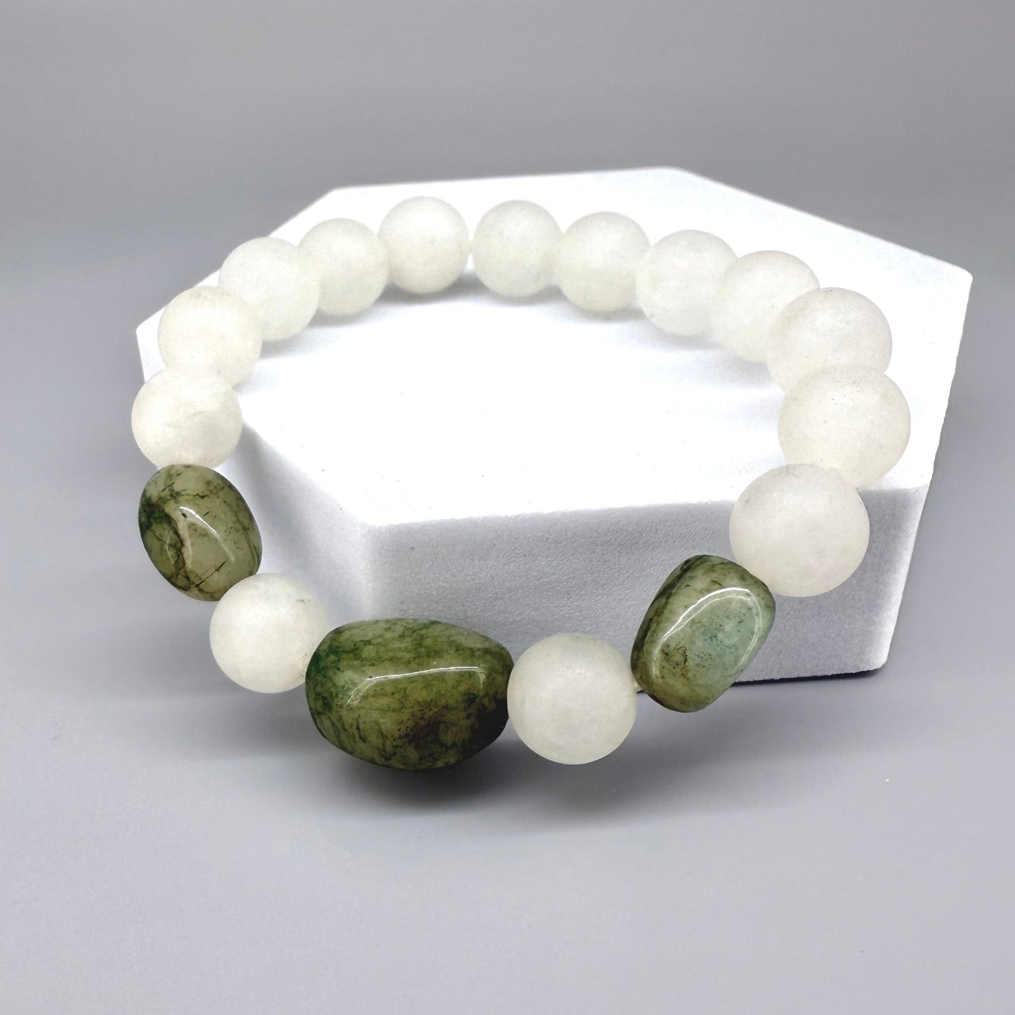 White jade beaded bracelet, 17cm, natural white gemstone beads with three larger oval emerald accents on elastic stretch band.