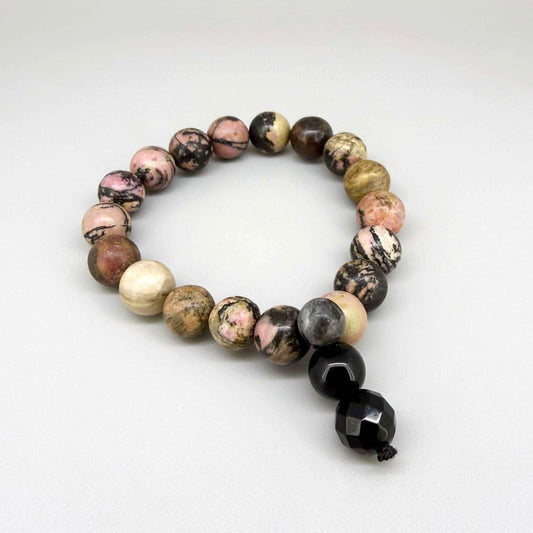 Rhodonite mala bracelet with natural pink gemstone beads and dark veining, featuring decorative charm detail.