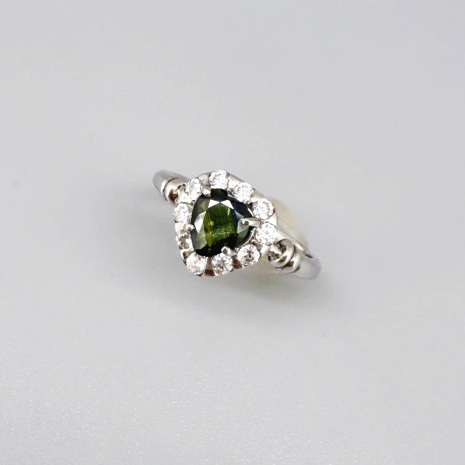 White gold plated silver solitaire ring with heart-shaped green sapphire and cubic zirconia centerpiece.