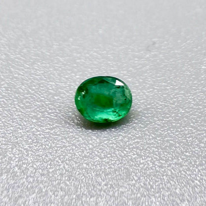 0.2 ct natural untreated Zambian emerald, oval faceted with vivid bluish-green color.