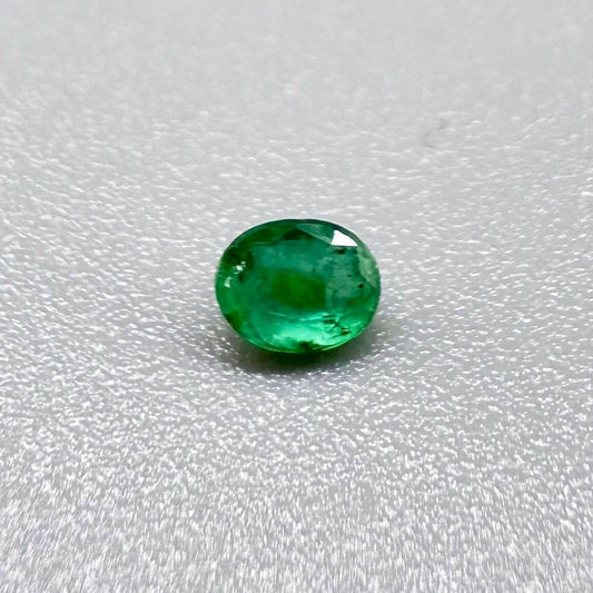 0.2 ct natural untreated Zambian emerald, oval faceted with vivid bluish-green color.