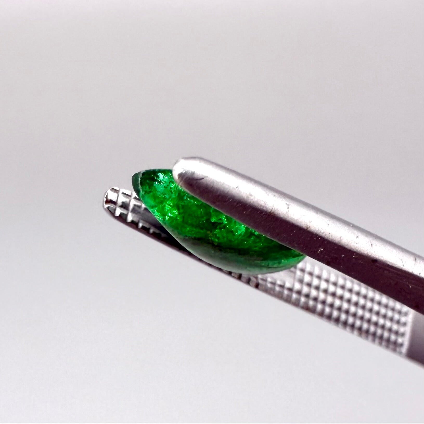 0.9 ct natural untreated emerald from Zambia, one side polished and the other cabochon-shaped.