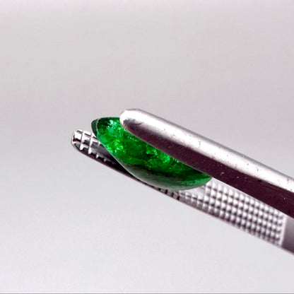 0.9 ct natural untreated emerald from Zambia, one side polished and the other cabochon-shaped.