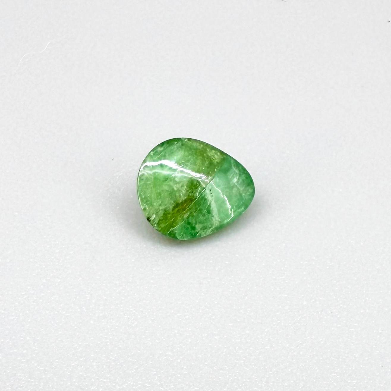 0.75 ct natural untreated emerald from Zambia, one side polished and the other cabochon-shaped.