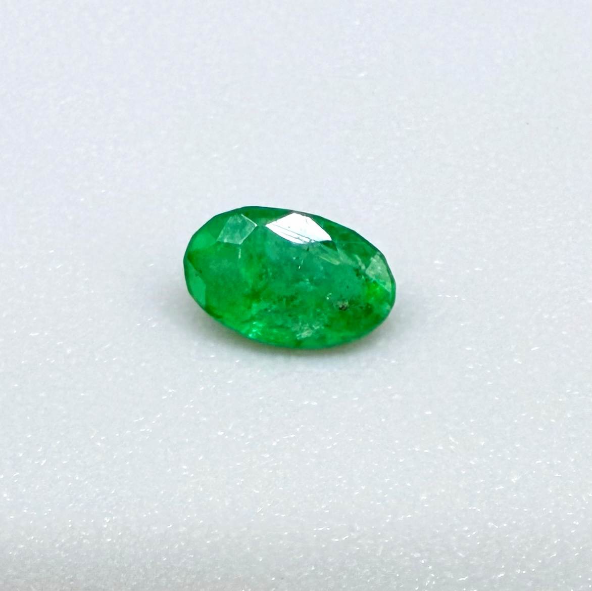 0.18 ct natural untreated Zambian emerald, oval faceted with vivid bluish-green color.