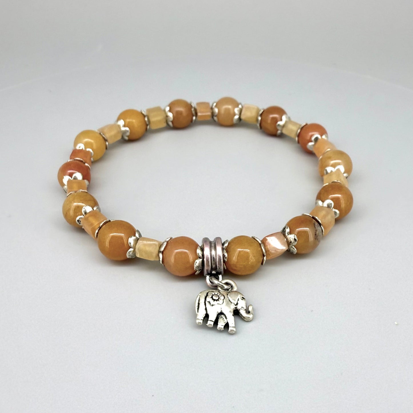Jade and aventurine beaded bracelet, 18cm, yellow and light brown gemstone beads in round and square shapes with elephant charm on elastic stretch band.