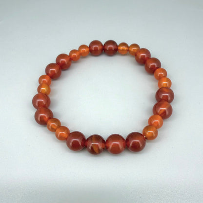 Carnelian beaded bracelet, 18cm, natural orange-red gemstone beads on elastic stretch band.