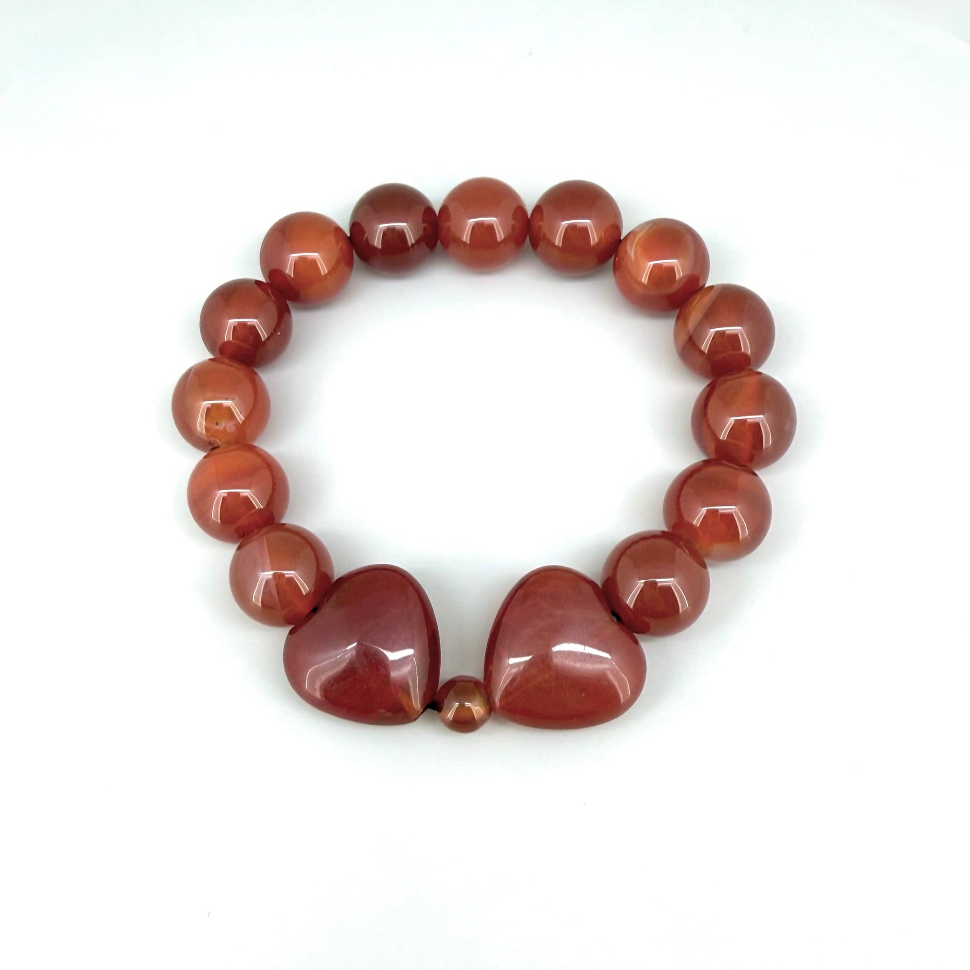 Carnelian beaded bracelet, 19cm, natural orange-red gemstone beads with two larger heart-shaped carnelian stones on elastic stretch band.