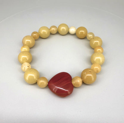 Jade and carnelian beaded bracelet, 20cm, yellow-cream jade beads with large heart-shaped orange-red carnelian focal stone on elastic stretch band.