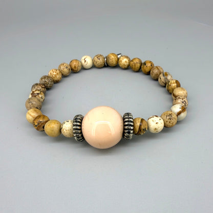 Jasper beaded bracelet, 18cm, light earthy tones with peach-colored focal bead on elastic stretch band.