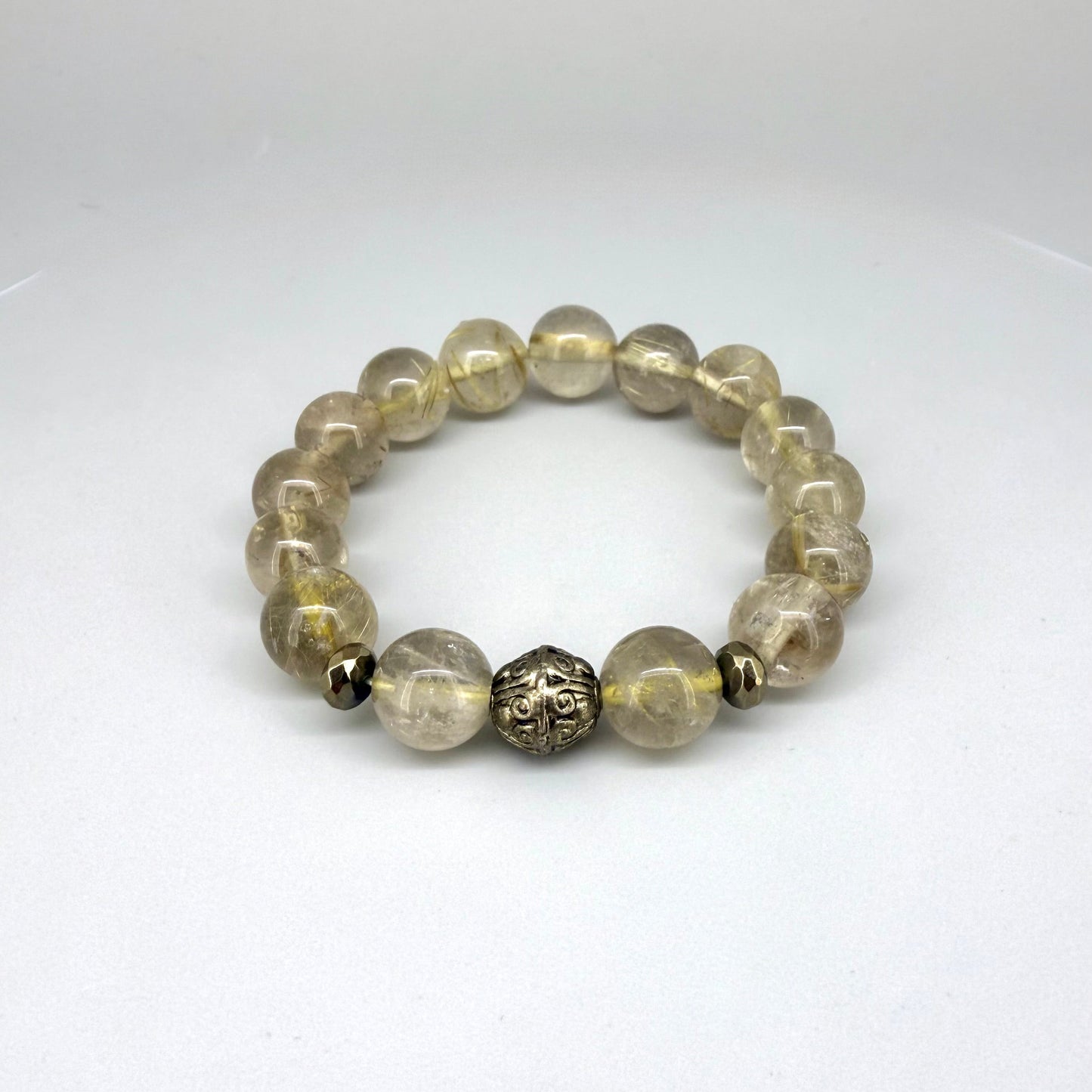 Rutilated quartz beaded bracelet, natural golden rutile gemstone beads with one carved metal accent bead on elastic stretch band.